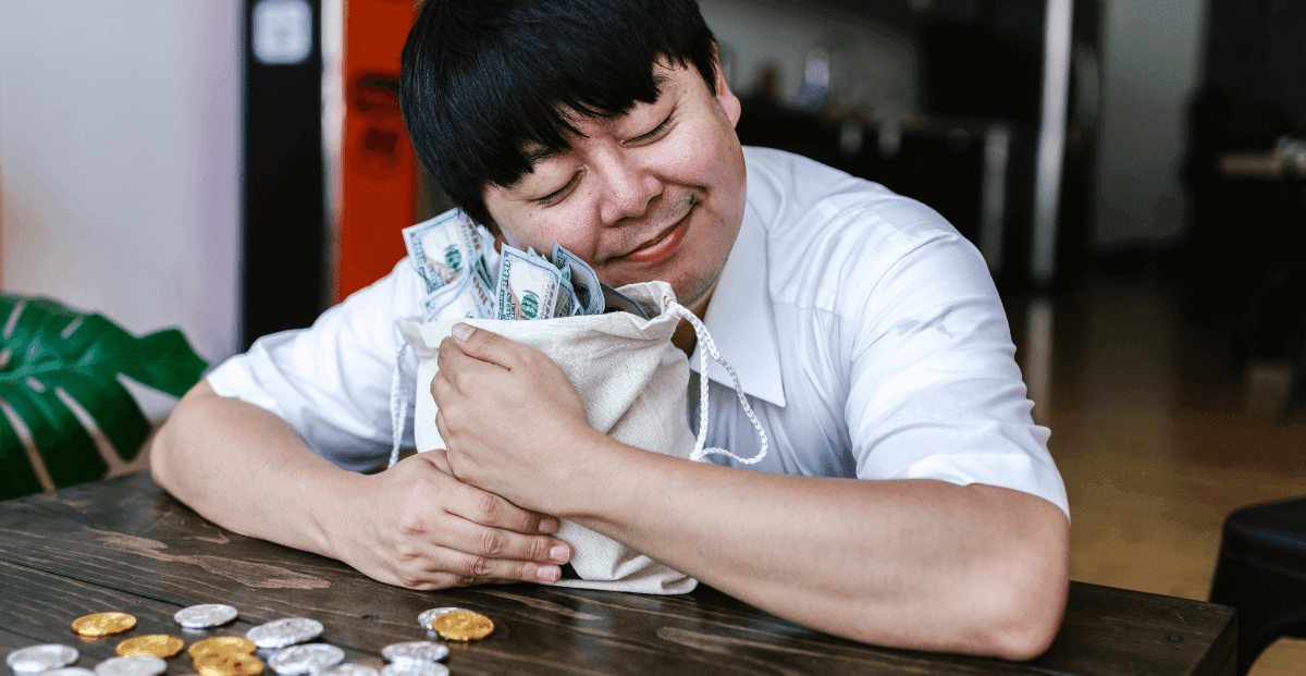 Um homem abraçado com um saco cheio de dinheiro